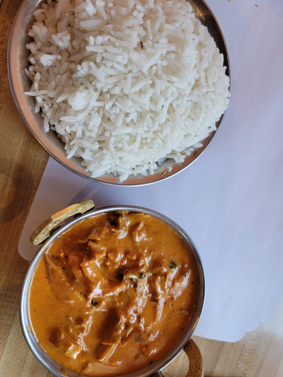 Butter chicken curry and basmati rice served in traditional kadhai bowls