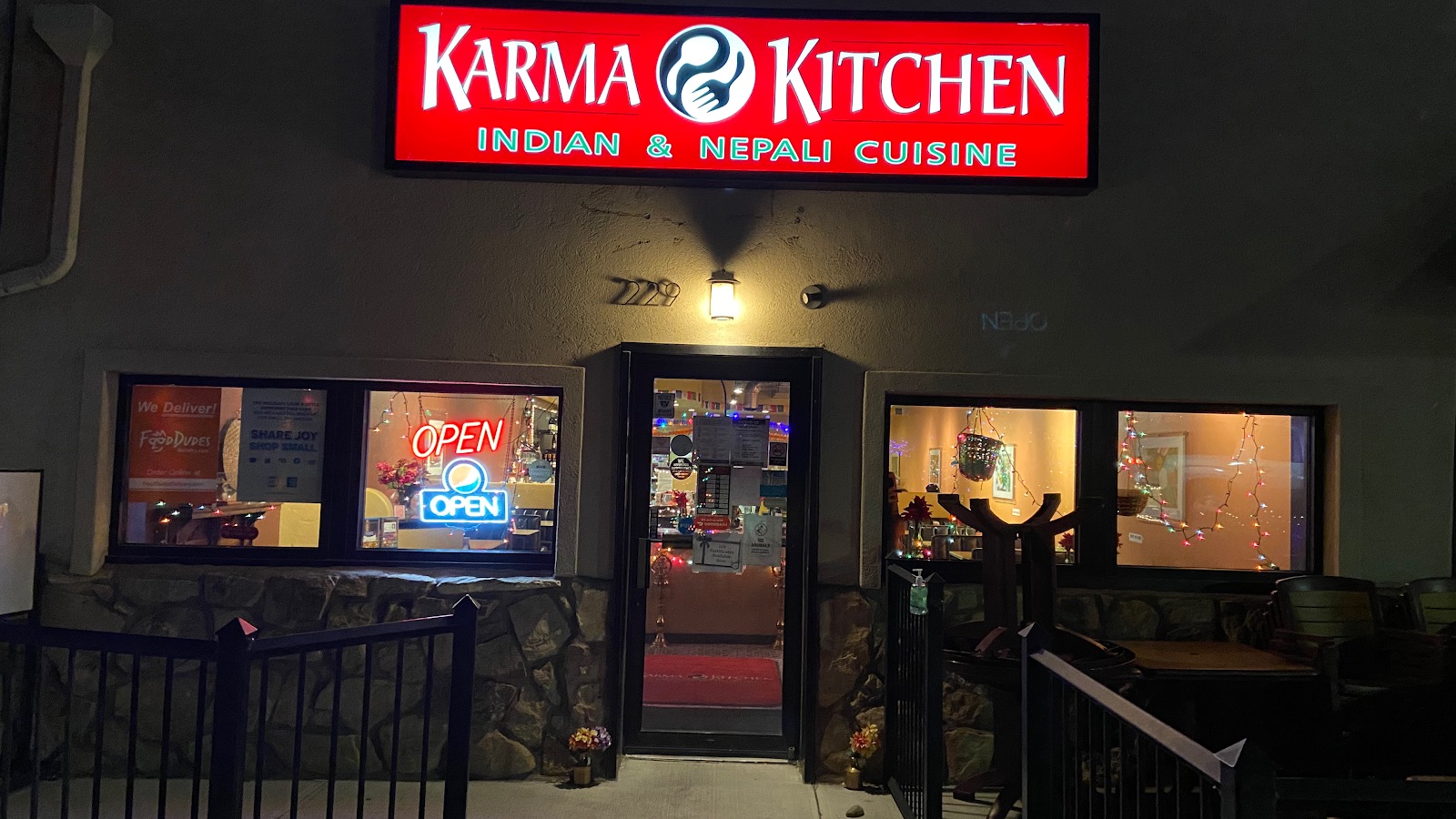 Karma Kitchen's storefront on E Aspen Ave at night, red illuminated sign and lit windows